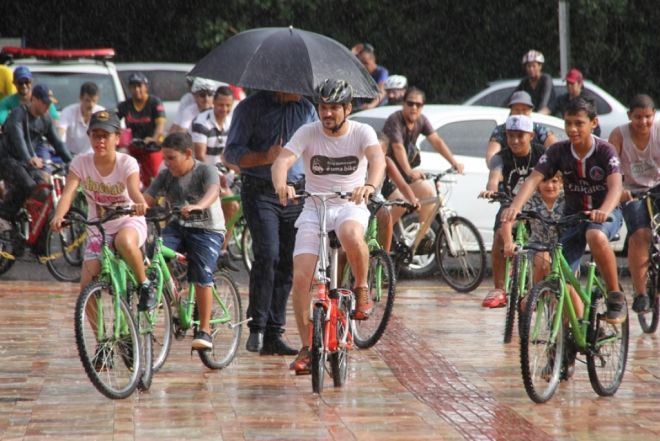  Vereador Eduardo Romero chega para participar da posse de bicicleta durante chuva