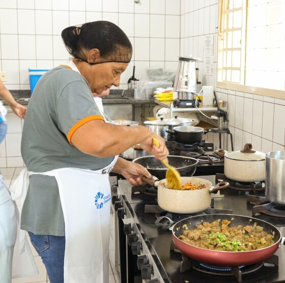Merendeira prepara alimento para os estudantes
