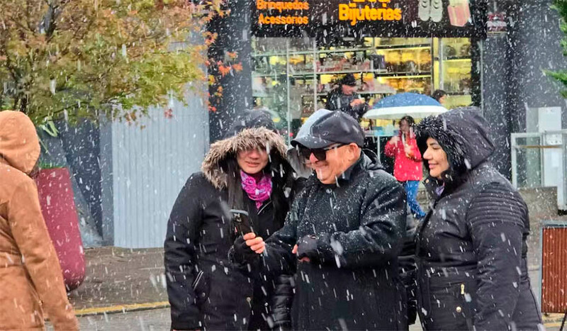 Turistas tiram foto na neve em São Joaquim