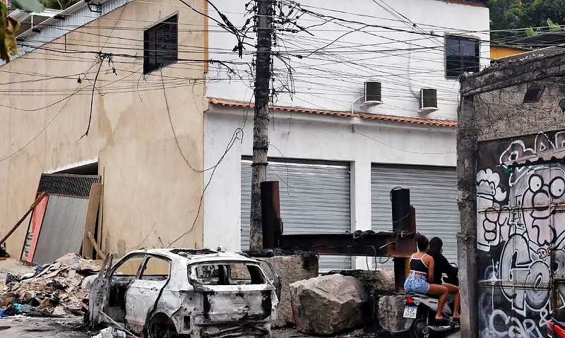 Rio de Janeiro (RJ), 30/10/2025 – Pessoas passam em moto na praça da Vila Cruzeiro ao lado de barricadas que foram colocadas para conter avanço de policiais durante a Operação Contenção